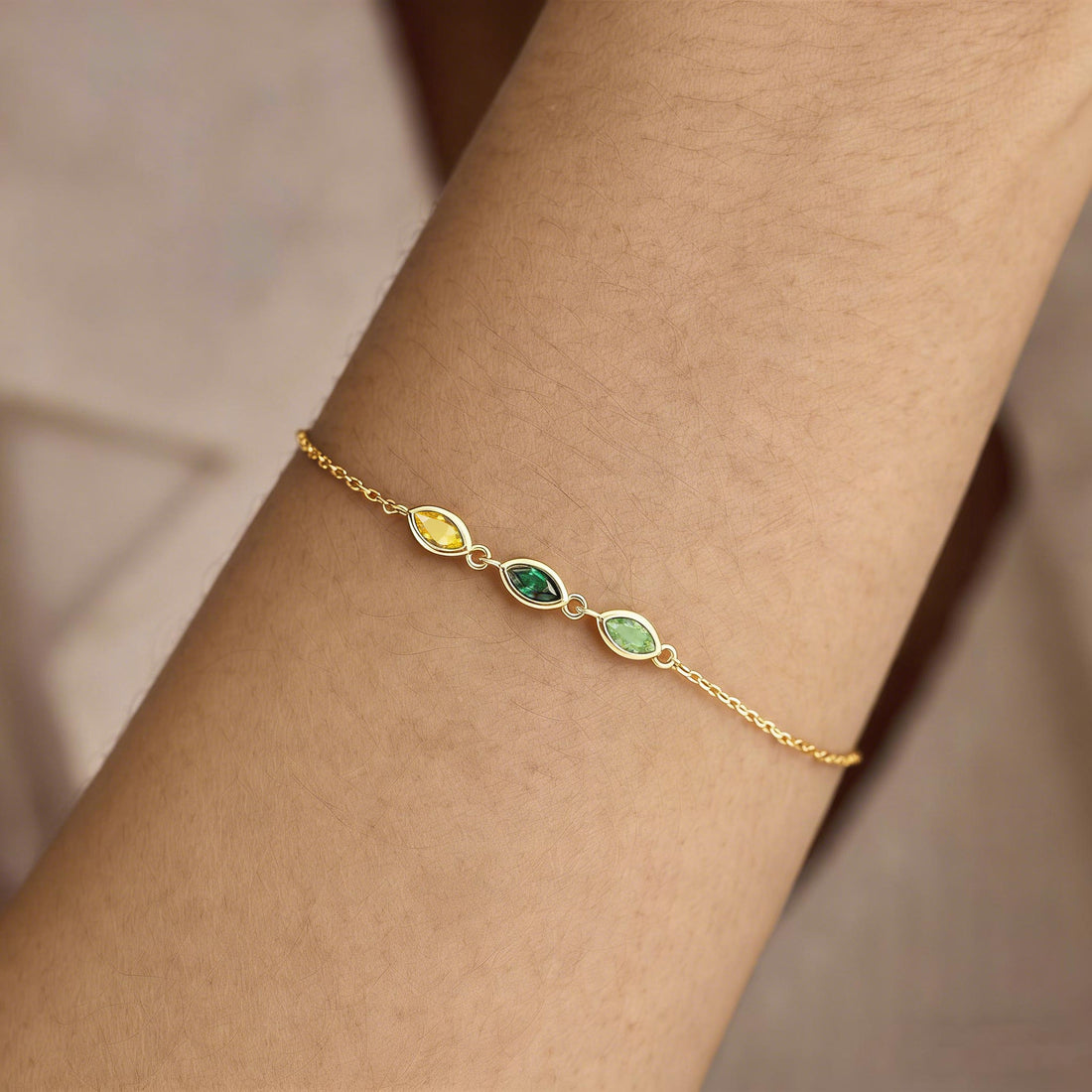 Gold bracelet with green gemstones on a white background, featuring the text 'Always & Forever'.